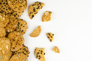 Broken oatmeal cookies with chocolate on white background with place for text