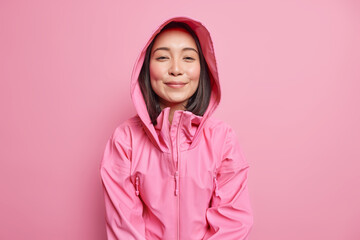Horizontal shot of pleased determined Asian woman has dark hair looks satisfied at camera wears...