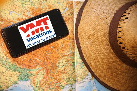 Leipzig, Germany - April 11, 2021: Closeup of smartphone with logo lettering of YMT vacations agency with sun hat and map (focus on center of lower lettering)