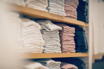 Stacks of clothes. Shopping in store. Clothing on the shelves in shop for sale. - 427059258