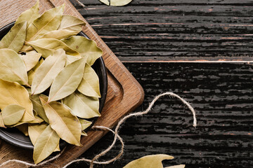Dry bay leaf spices on wooden background