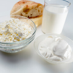 still life with dairy products, milk, bread and cheese on a white background