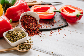 Dry seeds of pepper and raw fresh pepper on wooden background