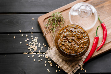 mixed sauce with different spicy herbs in glass bowl on wooden background