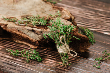 Raw green savory spices on wooden background