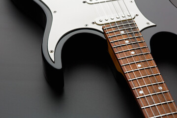 Electric guitar closeup, black background, nobody