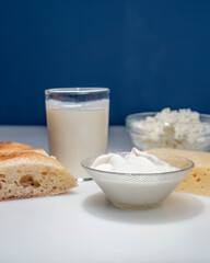 still life with dairy products, milk, bread and cheese on a white background