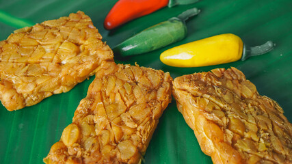 Selective Focus - Fried tempeh for snack on banana leaf. Made by a natural culturing and controlled fermentation process that binds soybeands into a cake form.