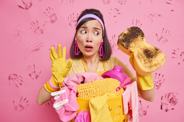 Puzzled Asian housekeeper tries to keeps home bright and clean shocked how much dust is in room...