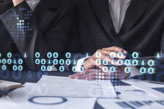 Two HR specialists analyzing the market of freshers to boost the intern program at international consulting company. Hiring new talented crew. Social media hologram icons. Women in business.