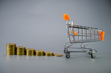 consumer shopping cart full of coins and stacks of coins in descending order.