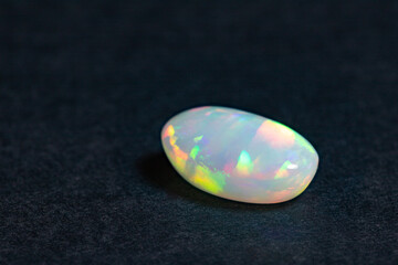 Colorful opal gem on black background