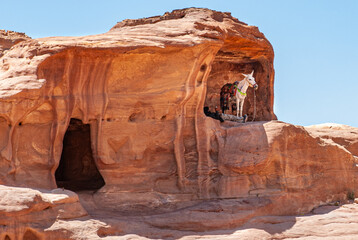 Fototapeta na wymiar White horse and man resting at Petra, Jordan