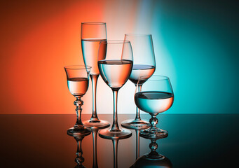Five glass goblets on a colored gradient background