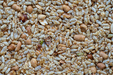 Granola bar. Healthy sweet dessert snack. Peanuts and rice with honey in background, close up