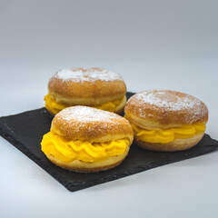 donuts on a plate with cream and with icing sugar