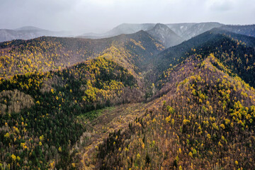 Surroundings of Lake Baikal. Khamar-Daban ridge. First snow in the mountains. Aerial view.