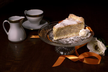 Photographic composition of a slice of Neapolitan Pastiera, typical Easter cake on a crystal backsplash and two elegant coffee cups.
Neapolitan Easter cake, shortcrust pastry filled with ricotta, mace