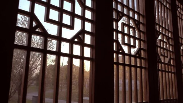 Chinese ancient traditional wooden decorative doors and windows, moving indoors, sunset background