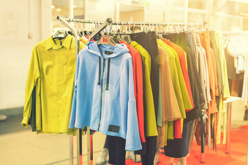 spring and summer women's clothing in the store. bright, modern clothes in a boutique. Women's hip clothing store interior concept. concept of choice of clothing. toned