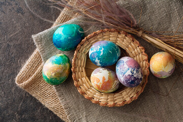 multi-colored Easter eggs of blue tones on a brown cloth background. Top view