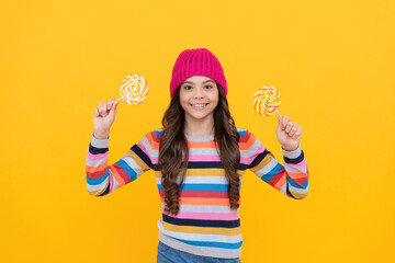 nice smile. hipster kid with colorful lollypop sugar candy on stick. caramel candy shop.
