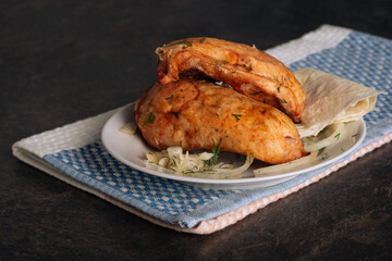 Delicious grilled chicken breasts on a plate on the dark background
