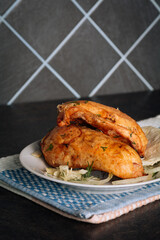 Delicious grilled chicken breasts on a plate on the dark background