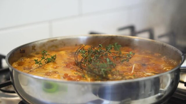 Pan of rich sauce cooking and bubbling in pan