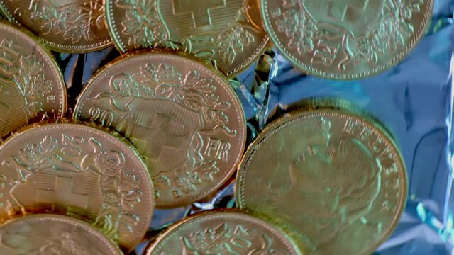 Close up spinning shot showing many rarely golden vreneli gold coins of swiss franc.