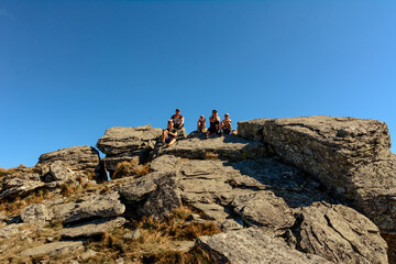 Fototapeta premium Family on one of the peaks of the Ukrainian Carpathians, parents and children admire the views of the Carpathians from Mount Smotrych, the Montenegrin ridge, rocky peaks in the Carpathians.