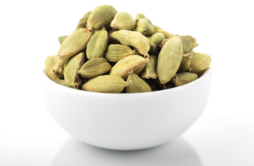 Cardamom, cardamom seeds, green cardamom. macro shot, cardamom seeds in white bowl,  on white background.
