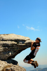 Tourist climber makes a climb on a large rocky rock without protection, the Ukrainian Carpathians, danger and extreme.
