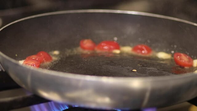 Close up of a chef sauteing and flambeing vegetables in a pan