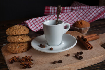 A cup of aromatic black coffee. Morning espresso or Americano coffee for breakfast in a beautiful cup. Cinnamon sticks. donuts. Wooden background.