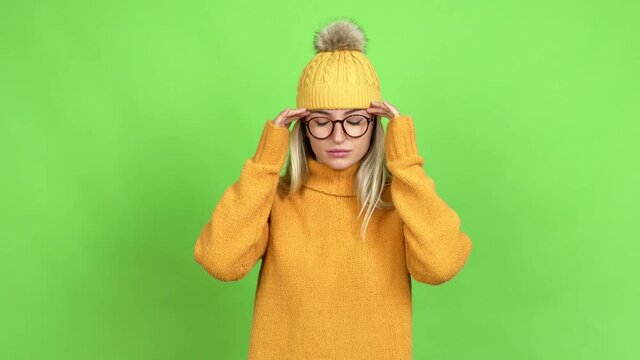 Young woman with glasses with headache over isolated background on green screen chroma key