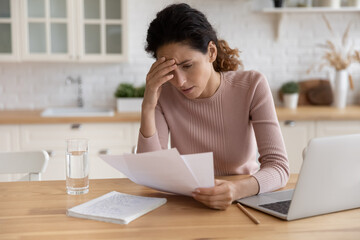 Worried stressed millennial female freelancer scratch forehead think on bank notification about...