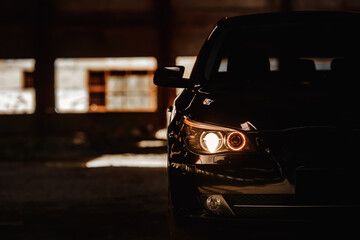Headlights of black modern car close up. Modern luxury car close-up banner background.