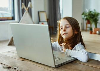 A girl learns at home at the computer