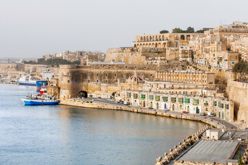 Panorama of Valletta, st.Barbara Bastion and fort Laskaris at early foggy morning. Architectural monuments on coast of Mediterranean sea in capital of Malta.