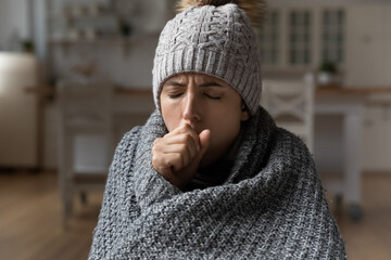 Cropped shot of ill millennial latina woman sit at home under warm blanket suffer from fever...