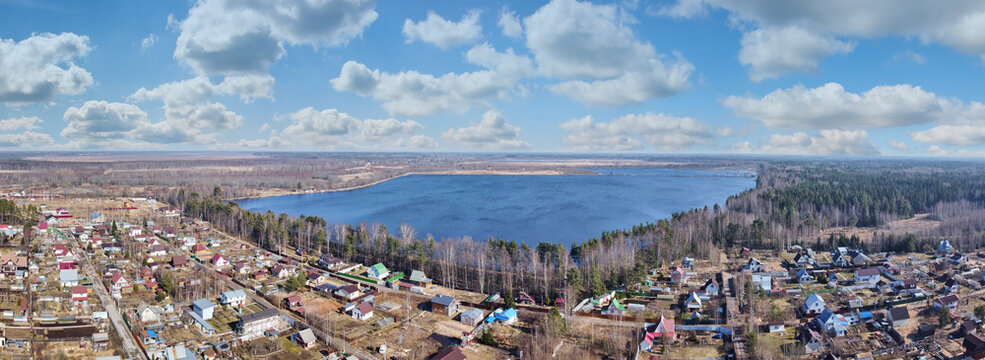 countryside with clowds above houses and lake