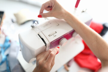 Top view of red thread on white sewing machine. Professional device for sew clothes