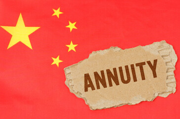 Against the background of the Chinese flag lies cardboard with the inscription - ANNUITY