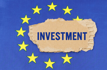 There is a cardboard box on the EU flag that says- INVESTMENT