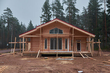 construction of a country cottage made of logs and timber in a green area. cozy eco-friendly house...