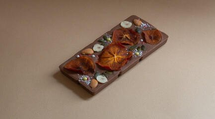 beautiful handmade chocolate with pieces of fruit and nuts  with space for text on brown background