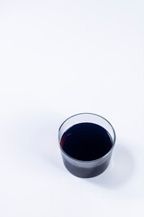 glass of red wine on white background. Vertical photography and selective focus
