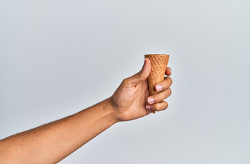 Hand of hispanic man holding biscuit cone over isolated white background.
