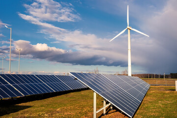 Solar cell plant and wind generators under blue sky. Powerplant with photovoltaic panels and eolic turbine.clean energy and eco energy concept.